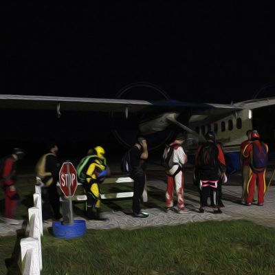 Skydivers boarding a Twin Otter to skydive over Spaceland at night