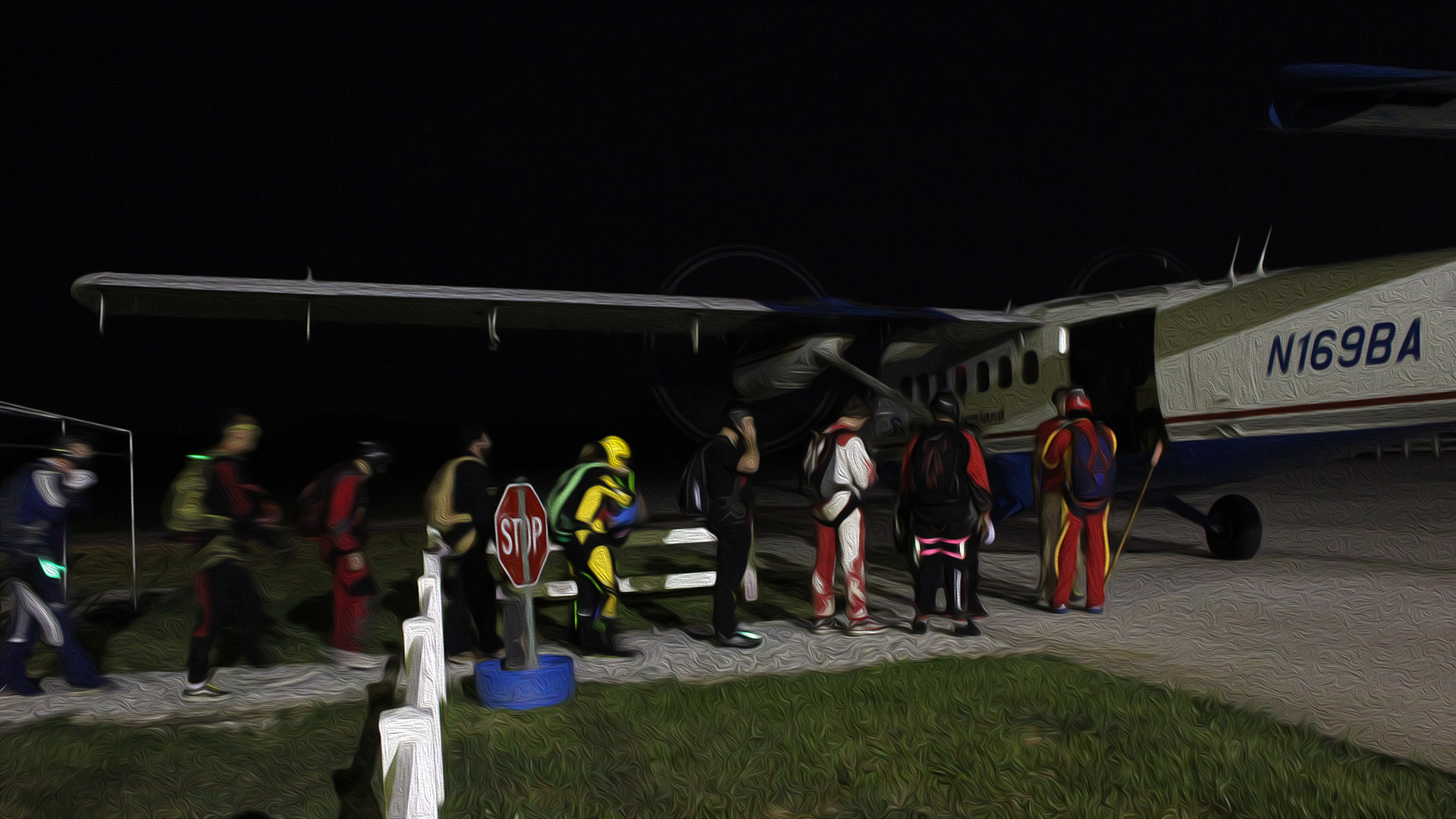 Skydivers boarding a Twin Otter to skydive over Spaceland at night